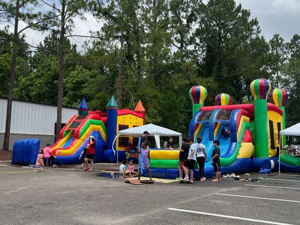 Multiple colorful inflatables set up for a community event